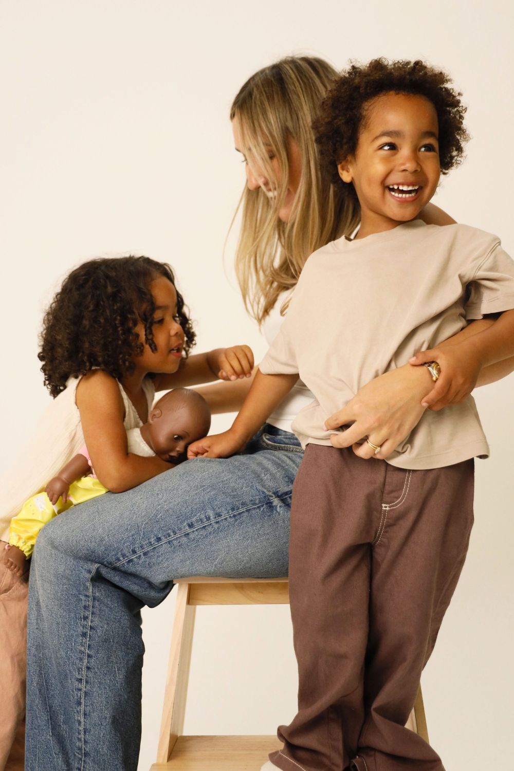 A playful sequence showing tickling and laughter while sitting on a couch.