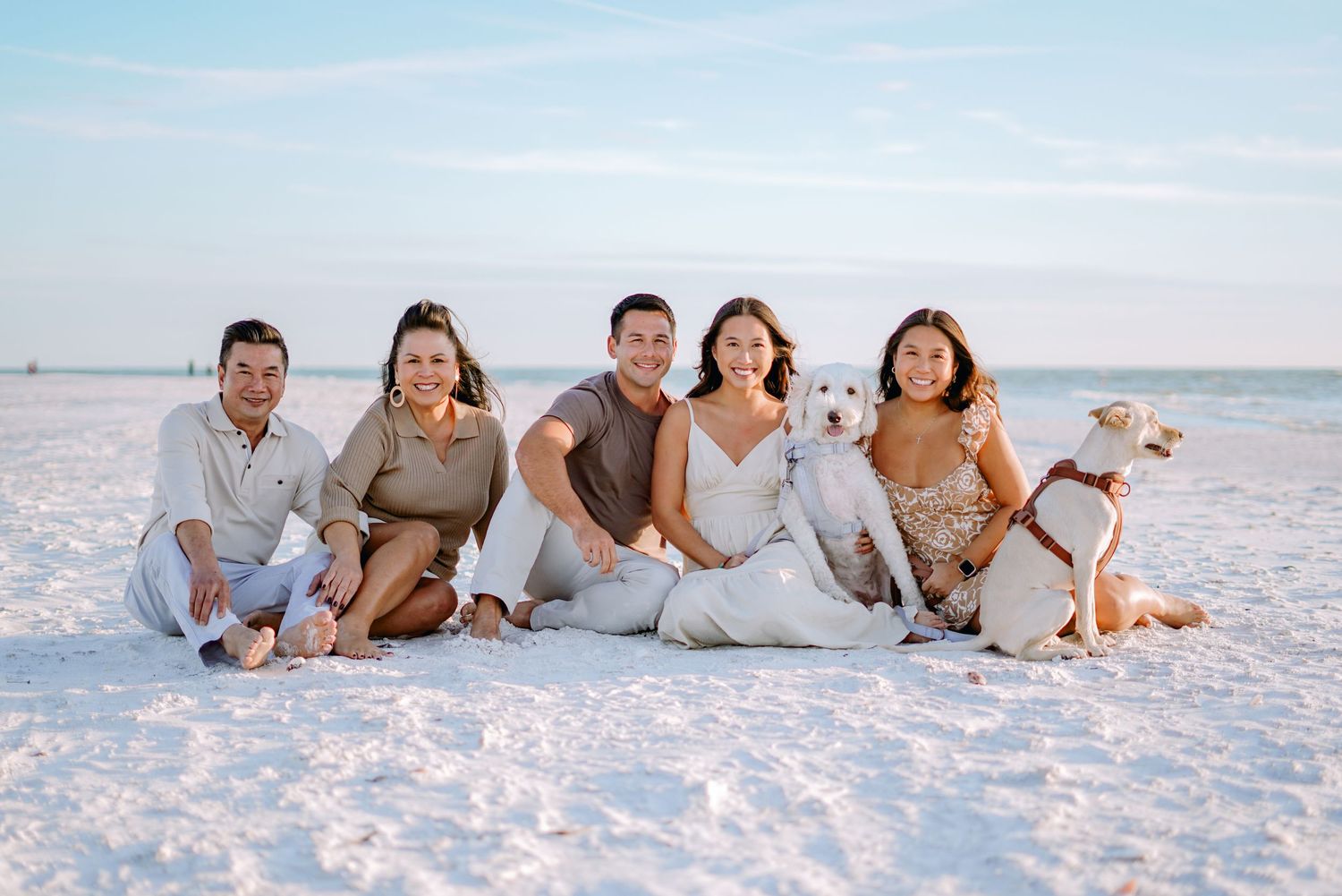 a happy family posing for a well-lit sunset photo on the beach