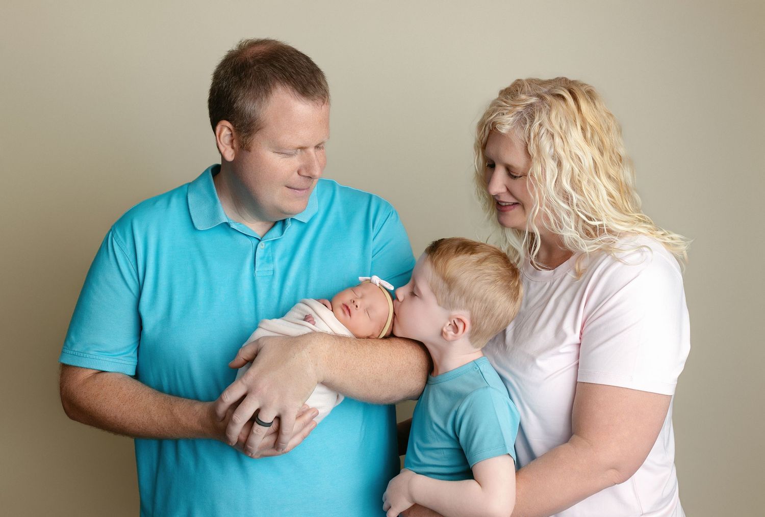 Family looking at the newborn baby and brother kissing her. Greenville SC newborn photographer, Easley SC newborn photographer