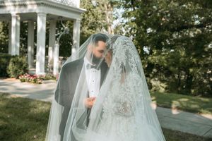 Bride and groom share intimate moments while walking through a classical columned structure.