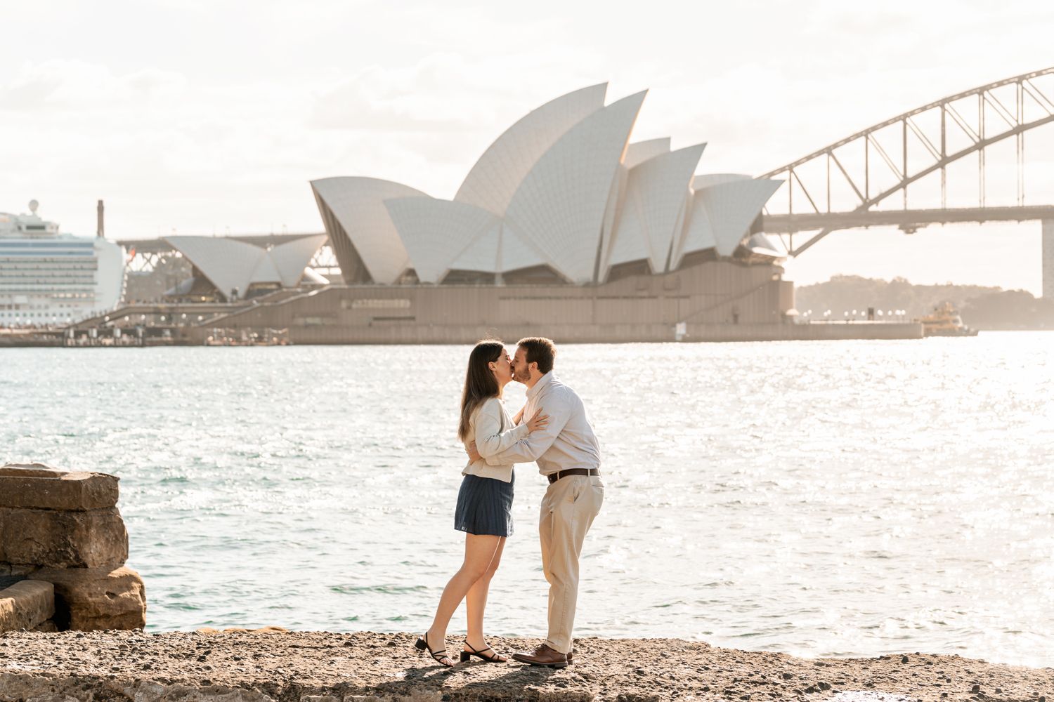 a man and a woman are hugging after a man proposed during a secret proposal photoshoot in Sydney