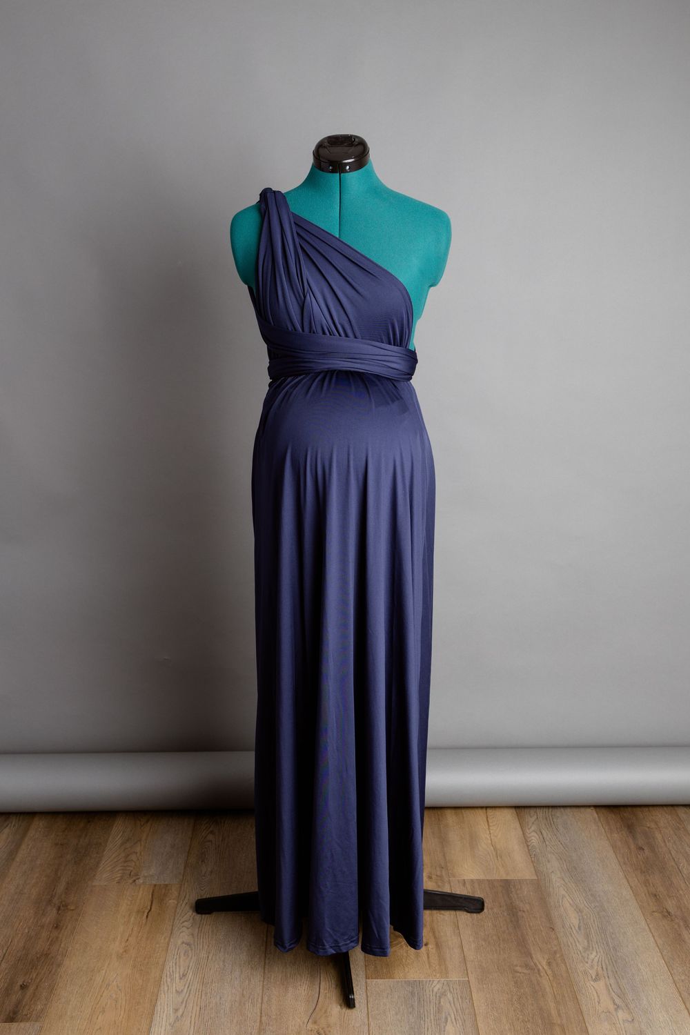Navy blue infinity gown displayed on turquoise dress form.