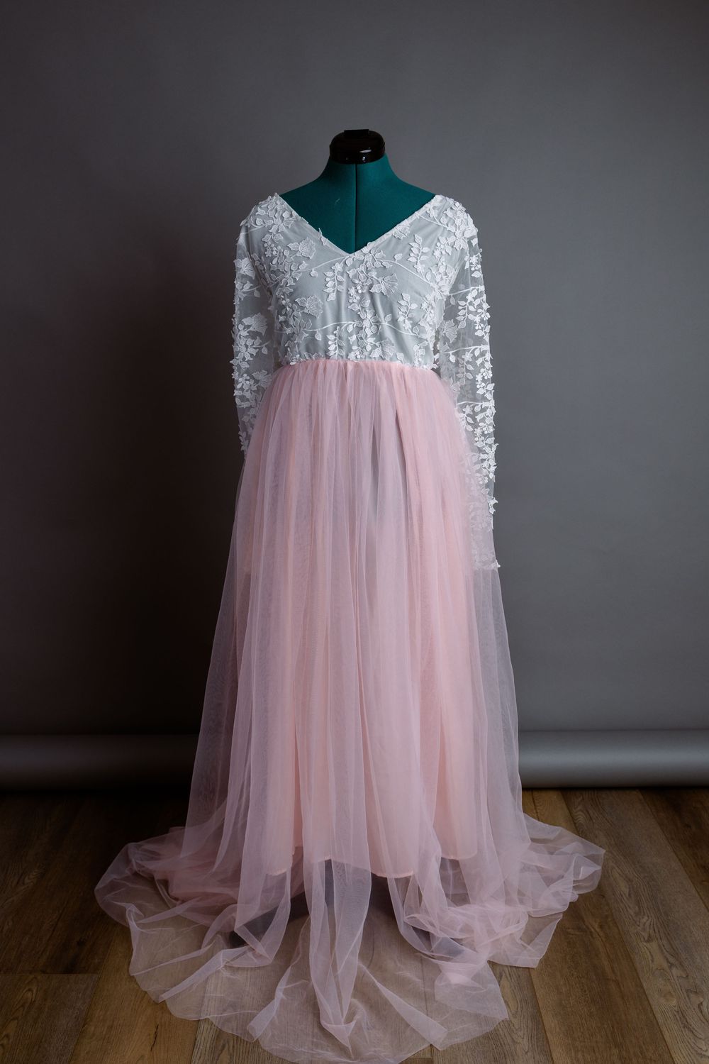 Pink tulle and silver sequin maternity gown with long sleeves on display.