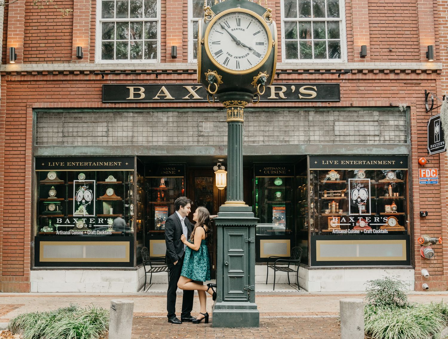 Historic brick storefront of Baxters restaurant with large windows and ornate clock mounted on the exterior facade.