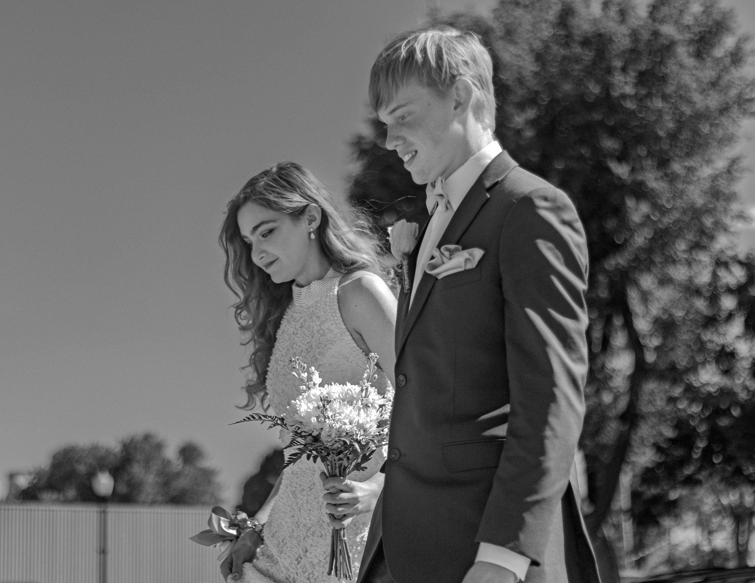 A couple at their wedding ceremony sharing an intimate moment while holding a bouquet.
