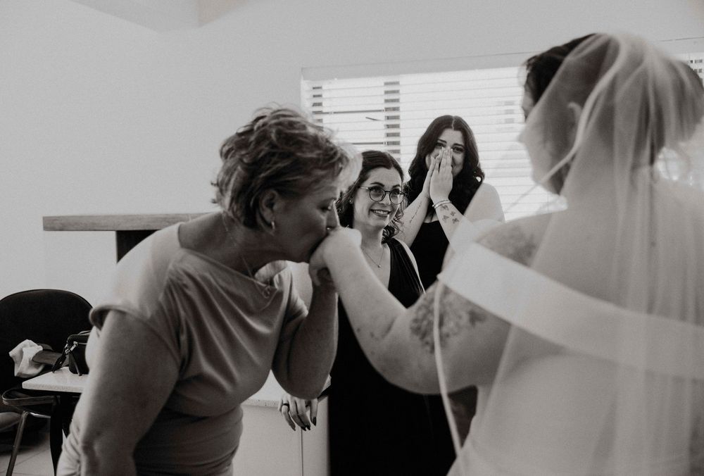 The Bride revealing her dress to her emotional bridesmaids and mom.