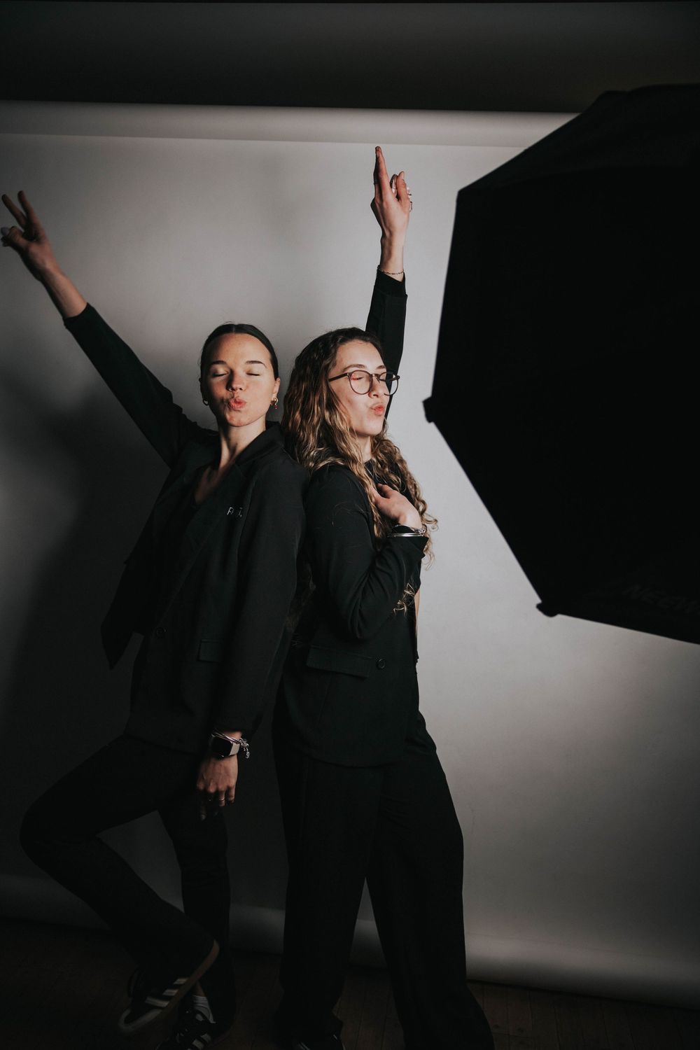Set de fotografía minimalista con modelo de negro sobre fondo blanco, ideal para estudio de fotografía móvil para eventos