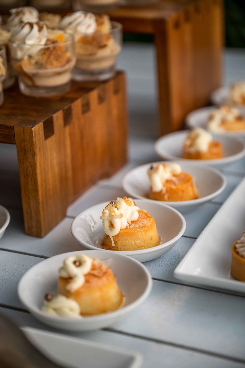 Gourmet desserts plated on white dishes with cream toppings.