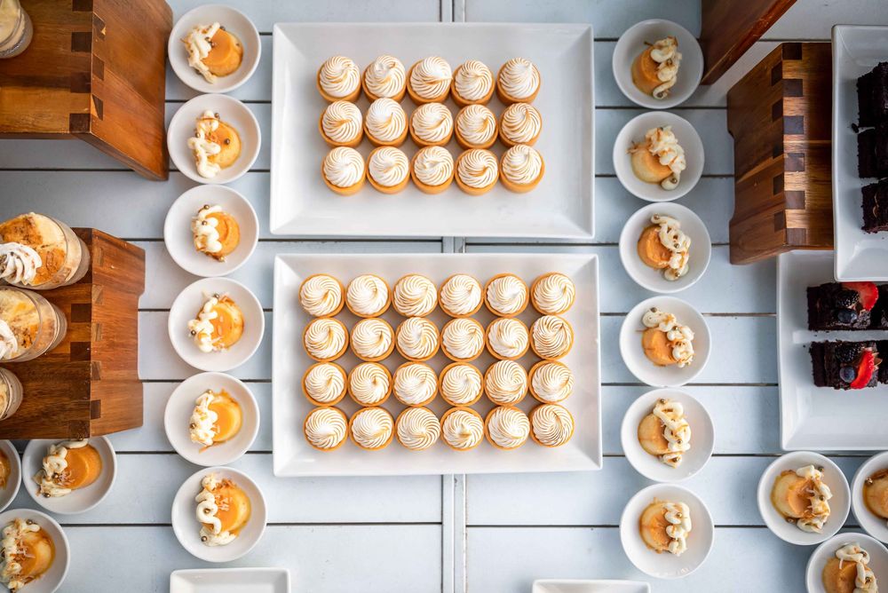 Catering display of multiple appetizer plates arranged on light blue surface.