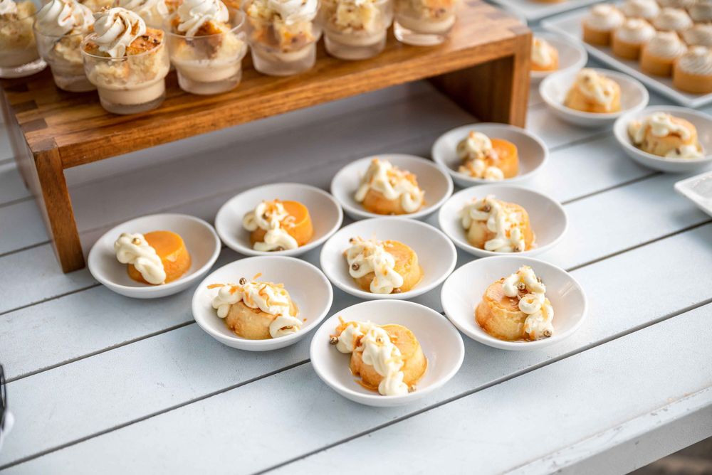 Rows of elegant appetizers displayed on white plates with wooden serving boards.