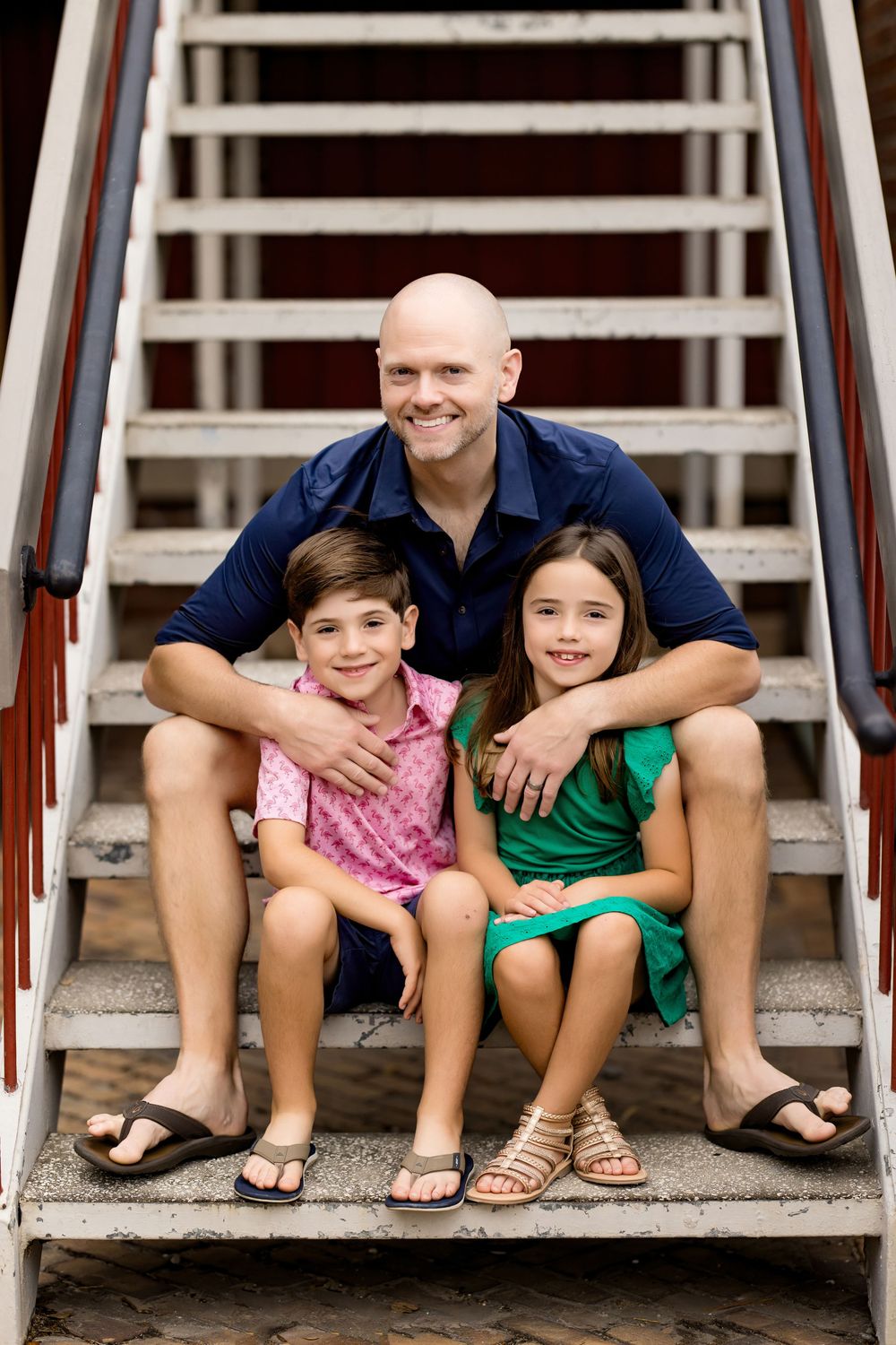 Group portrait of family members bonding on concrete steps.