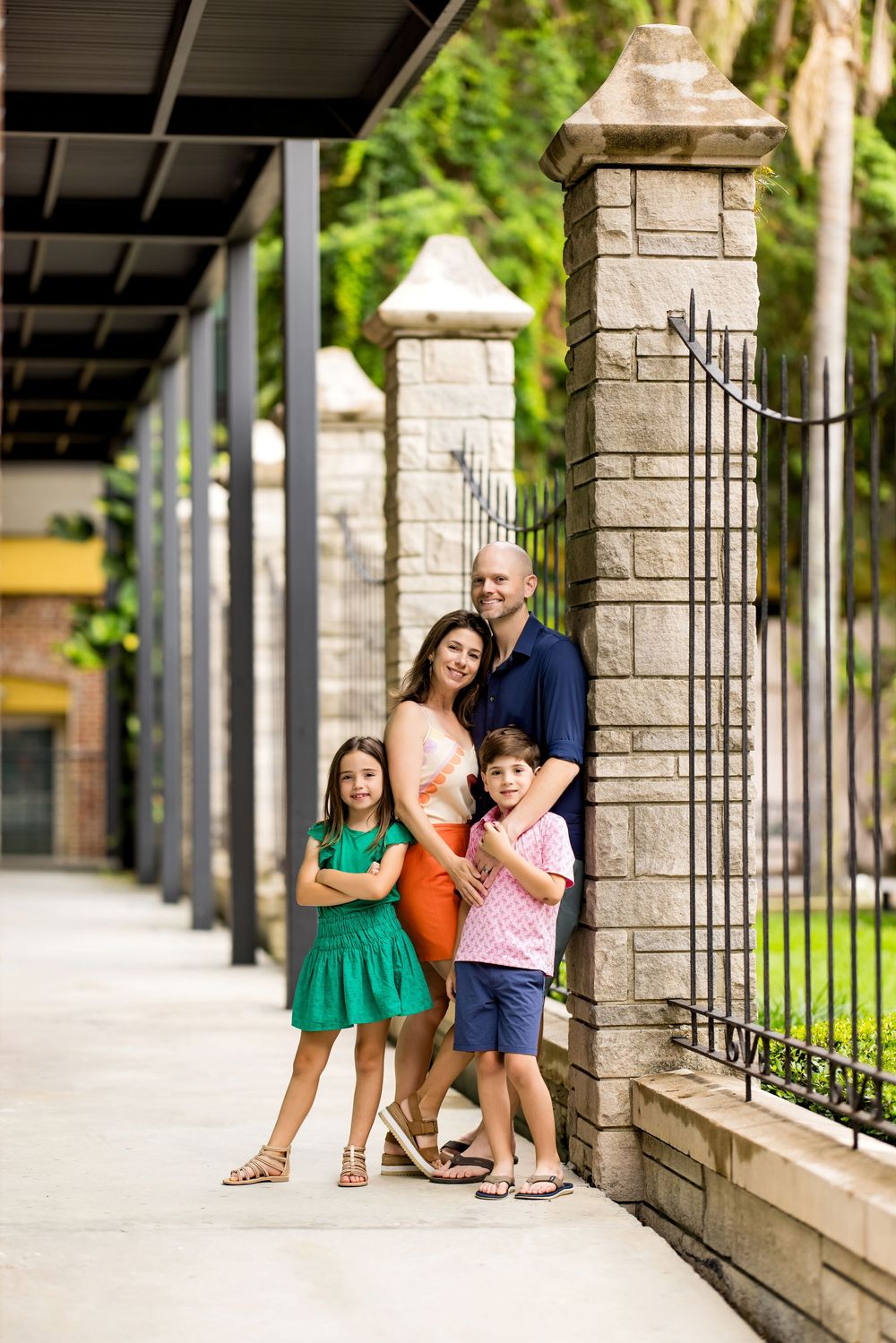 Family group leaning against stone pillars in covered outdoor walkway. Photos by Tampa Photographer DigitalMyst Photography