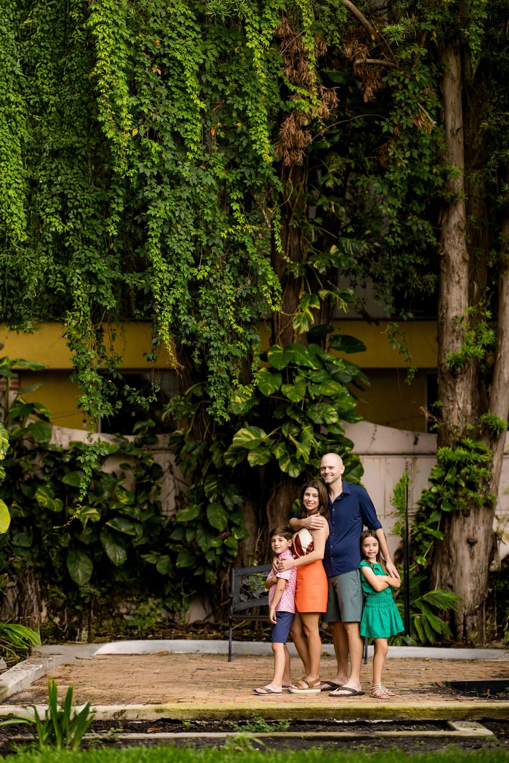 Family group posing among ivy-covered walls and greenery.