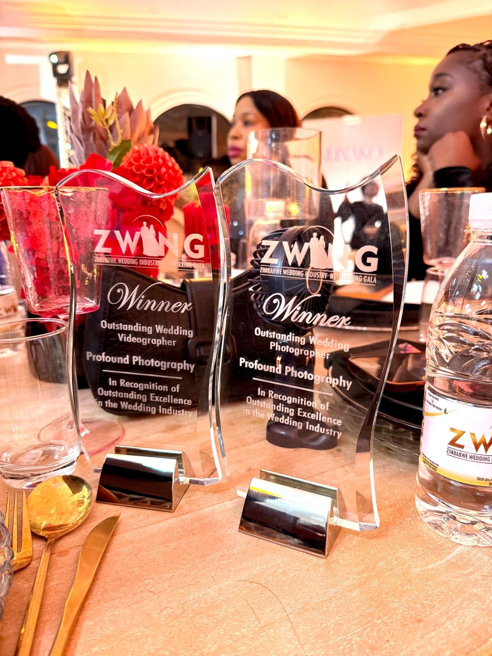 Crystal glass ZWING award trophies and cocktail glasses displayed on a table at an event.