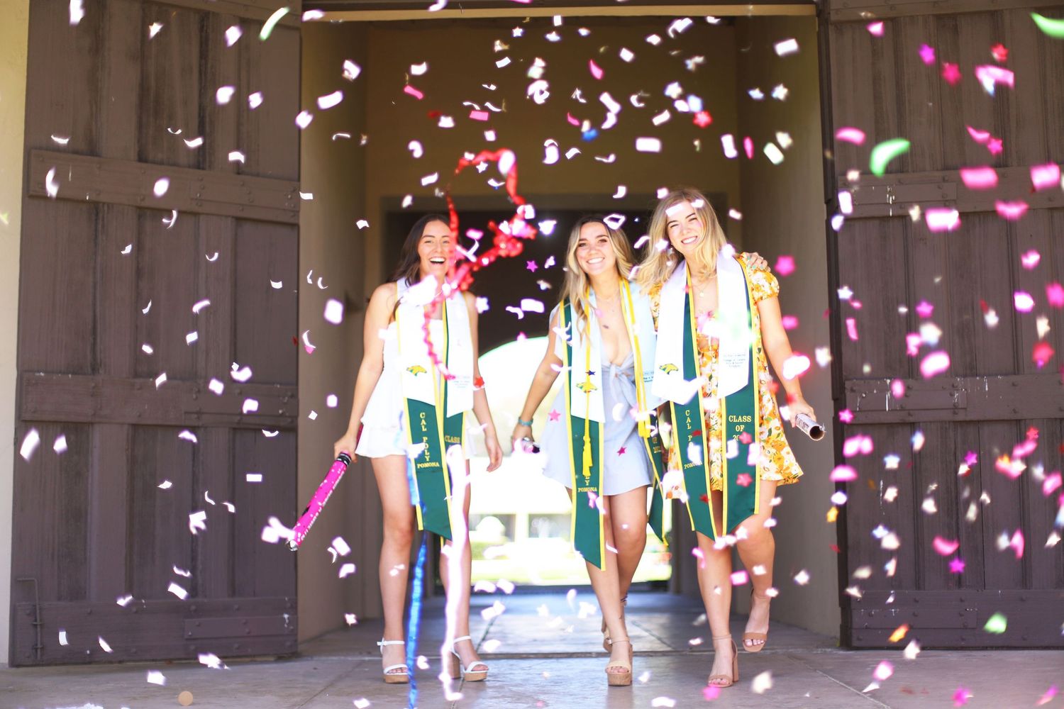 People celebrating indoors with confetti falling while holding shopping bags in a festive atmosphere.