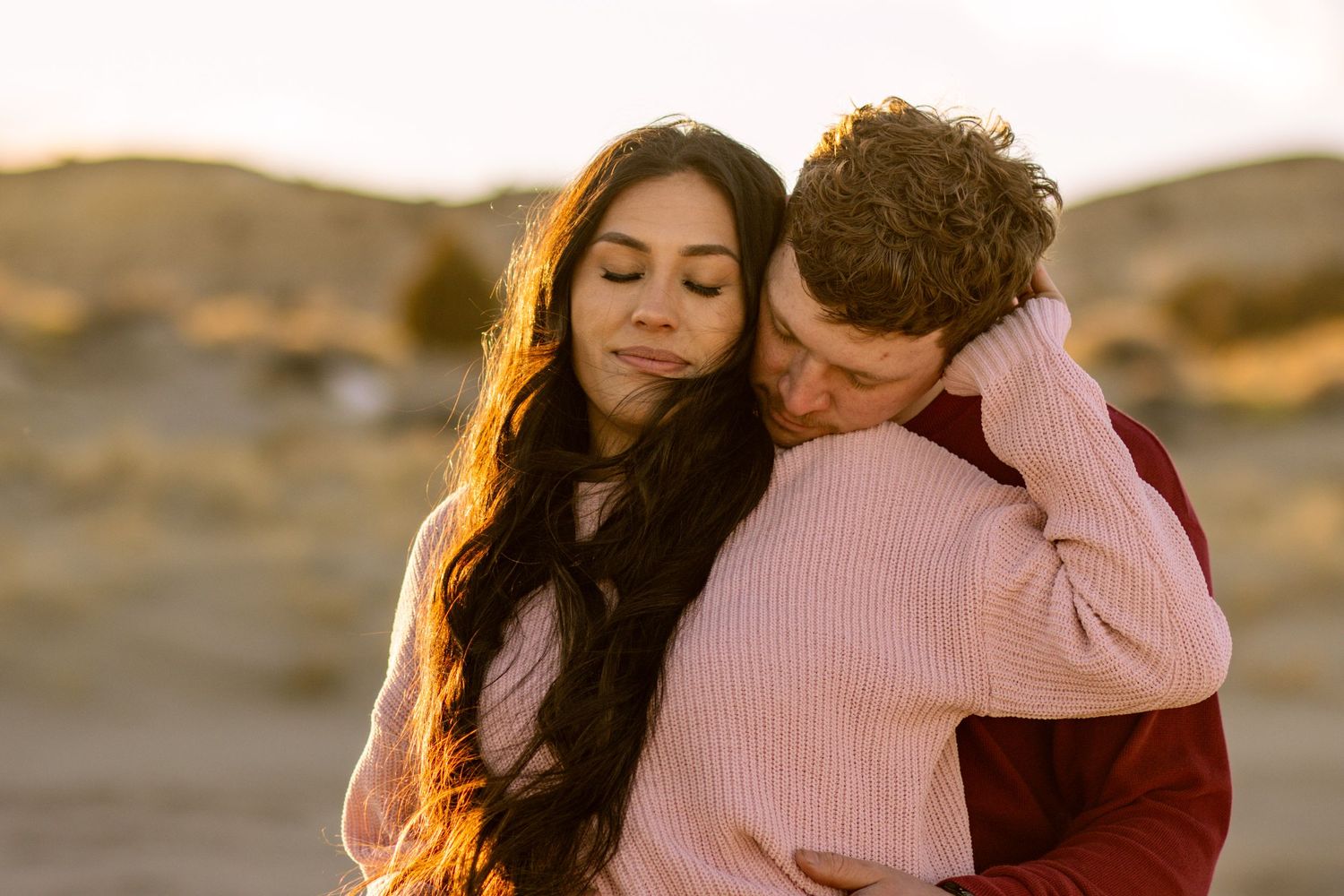This couple shared a gorgeous embrace during this gold pen hour sand dunes engagement session in Utah