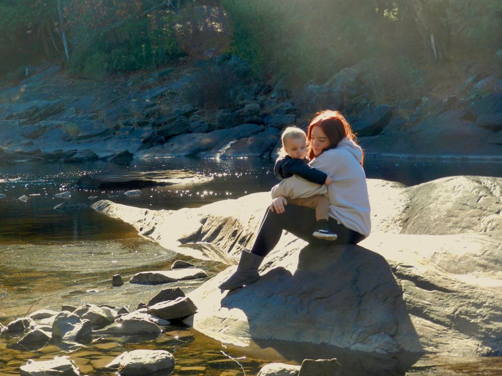aunt and nephew on a rock by water