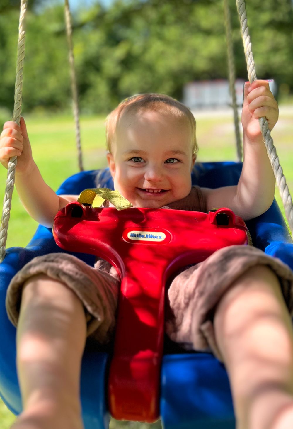 baby on a swing in the summer