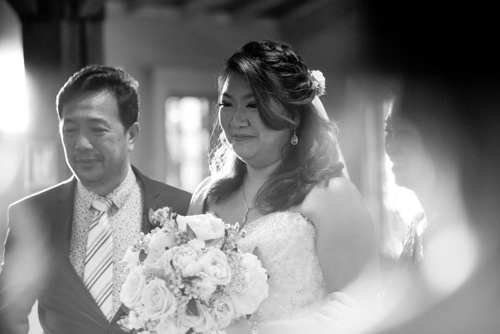 A black and white wedding photo capturing a candid moment with soft bokeh effects.