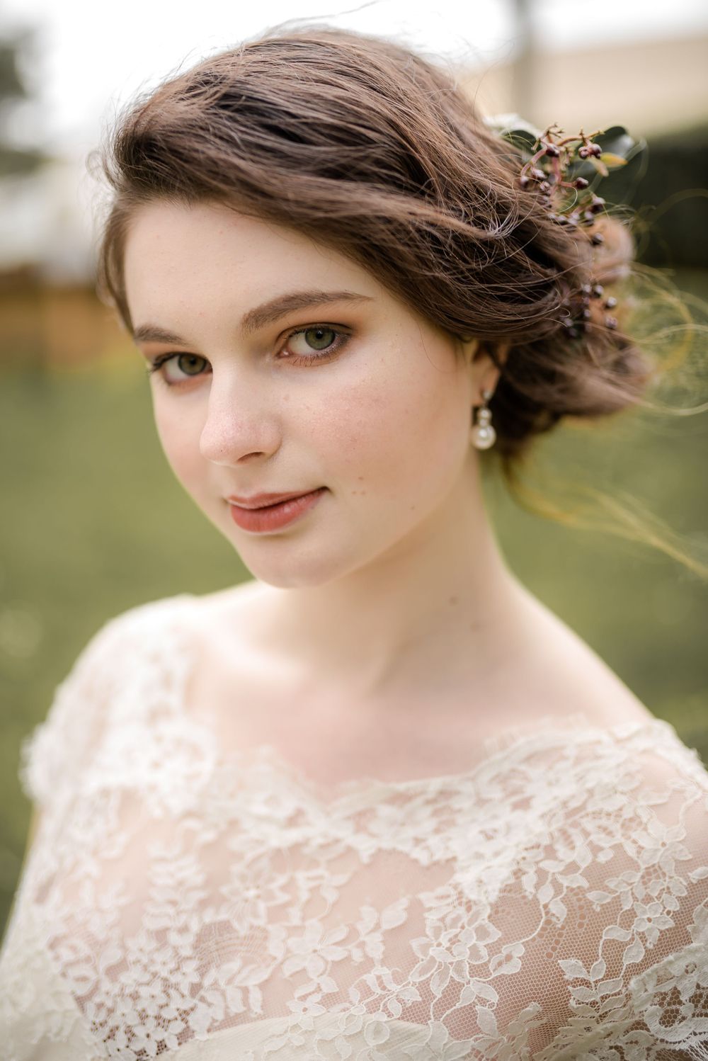 Classic bridal portrait featuring delicate lace details and natural makeup in an outdoor setting.