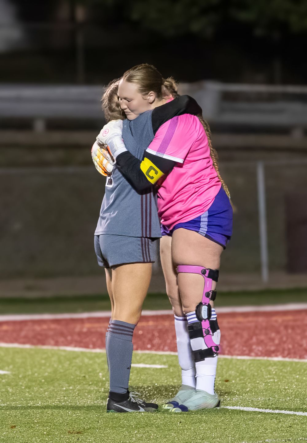 Soccer players share a moment of sportsmanship during a match on the field.