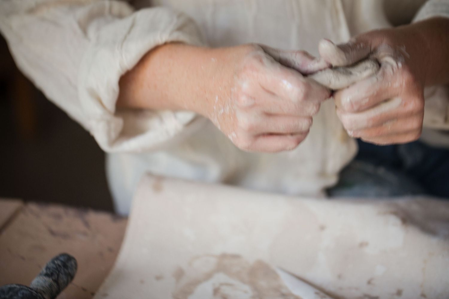 Hands working with clay on a pottery wheel, shaping and molding the material with delicate precision.