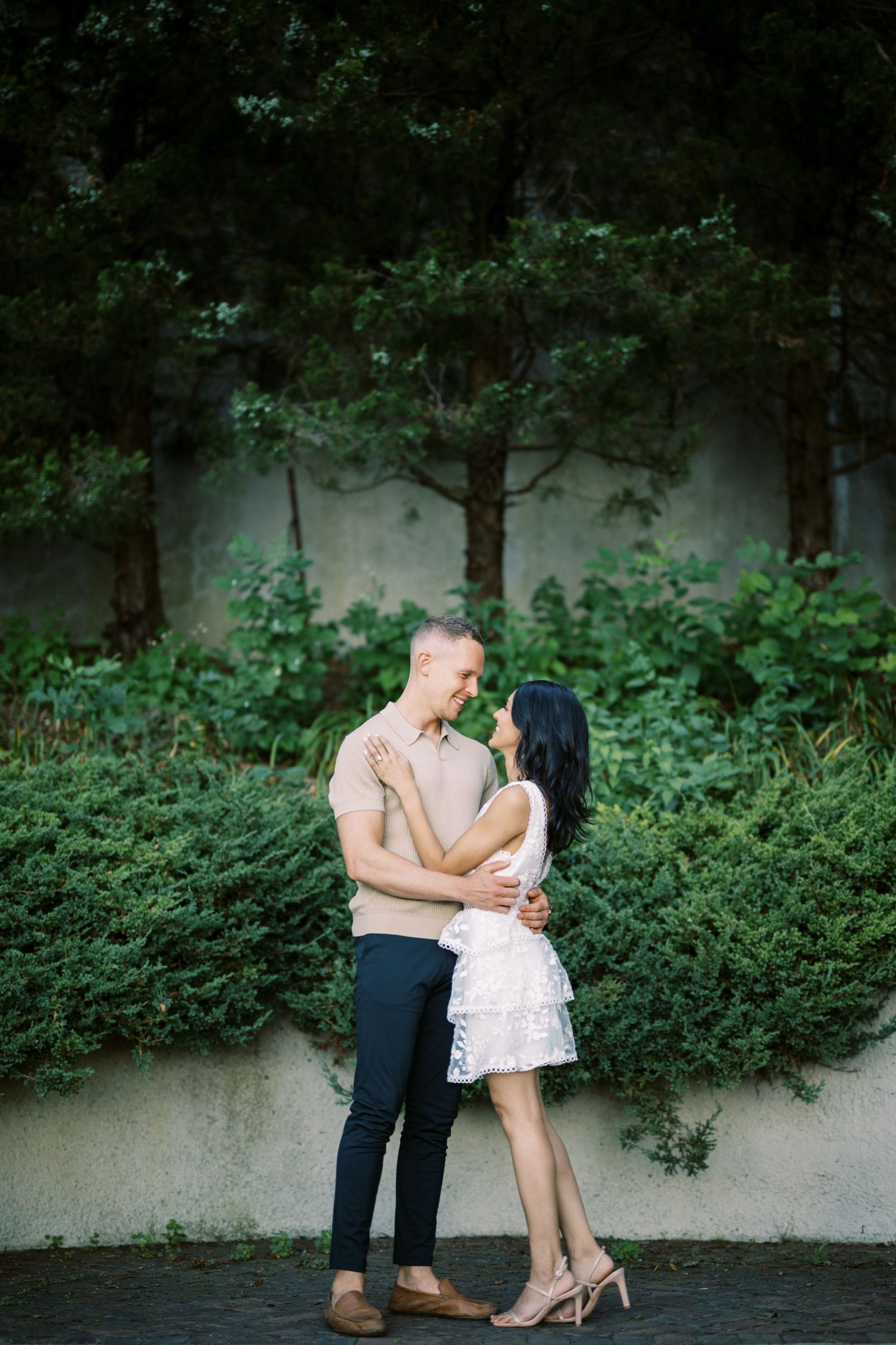A couple embraces in a romantic pose against a misty forest backdrop.