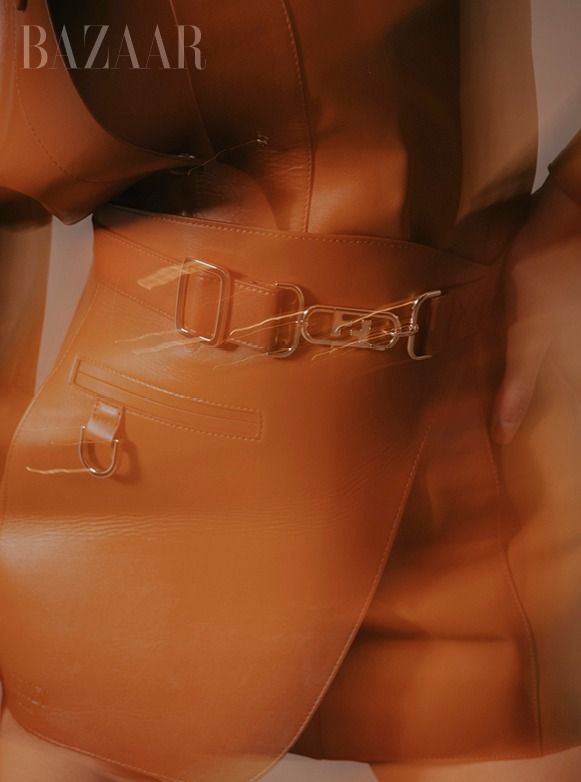 Close-up fashion editorial shots in muted orange tones with leather garments.