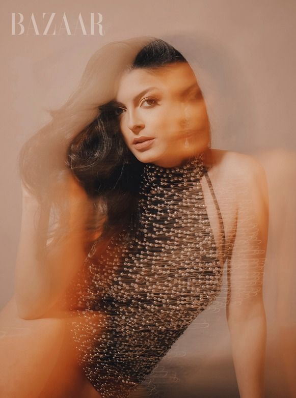 Artistically blurred fashion portrait with metallic embellished clothing.