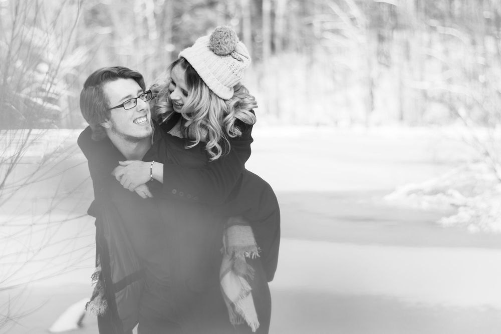 A tender embrace captured in black and white against a snowy winter backdrop.