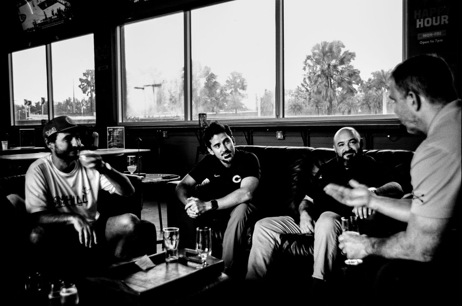 Interior of a bar with patrons sitting in window booth.