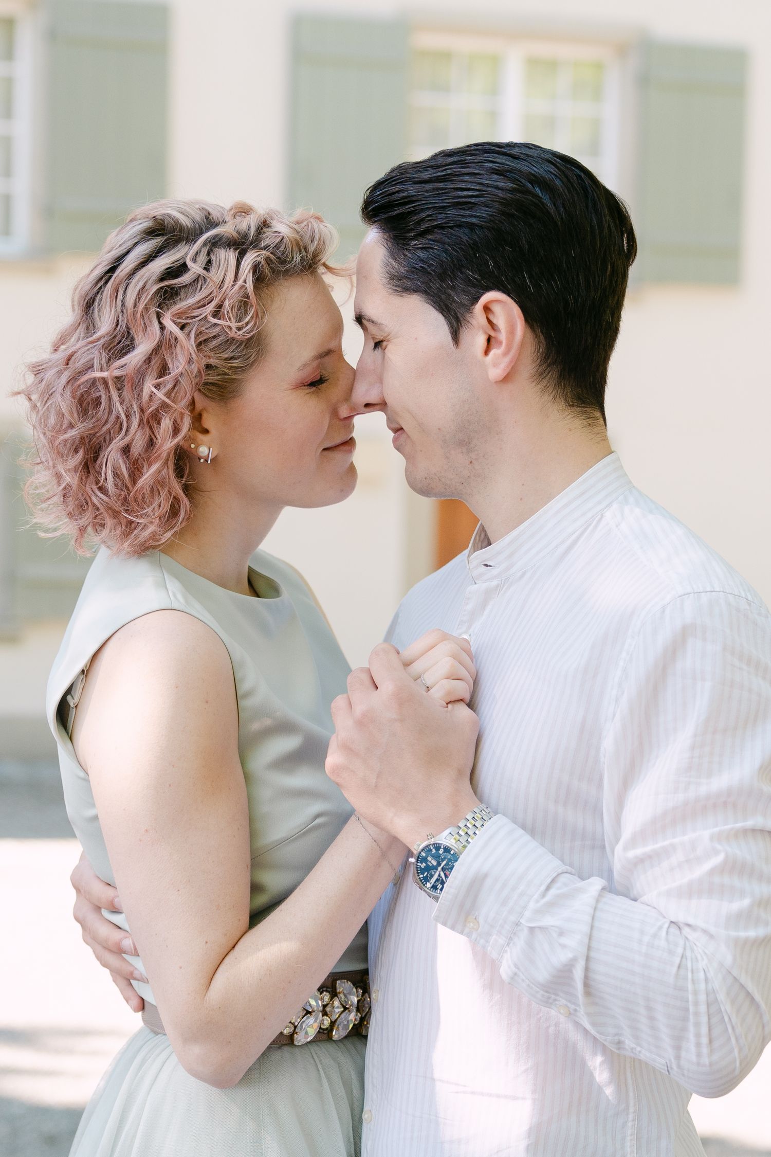 Elegant couple in vintage-inspired outfits dancing in garden setting.