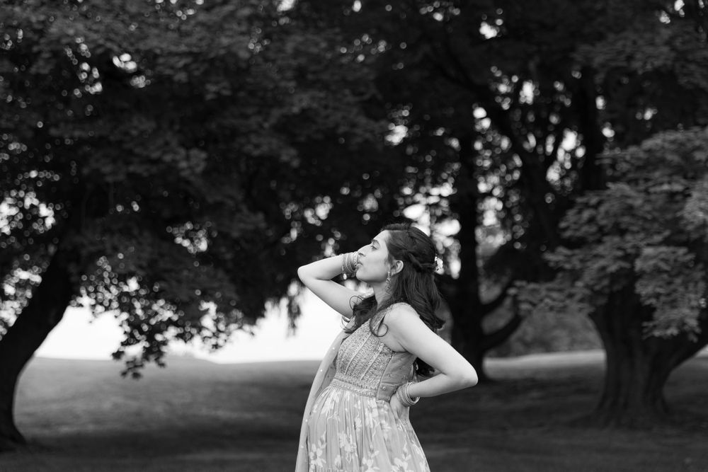 A black and white artistic portrait of someone twirling in a flowing dress outdoors.
