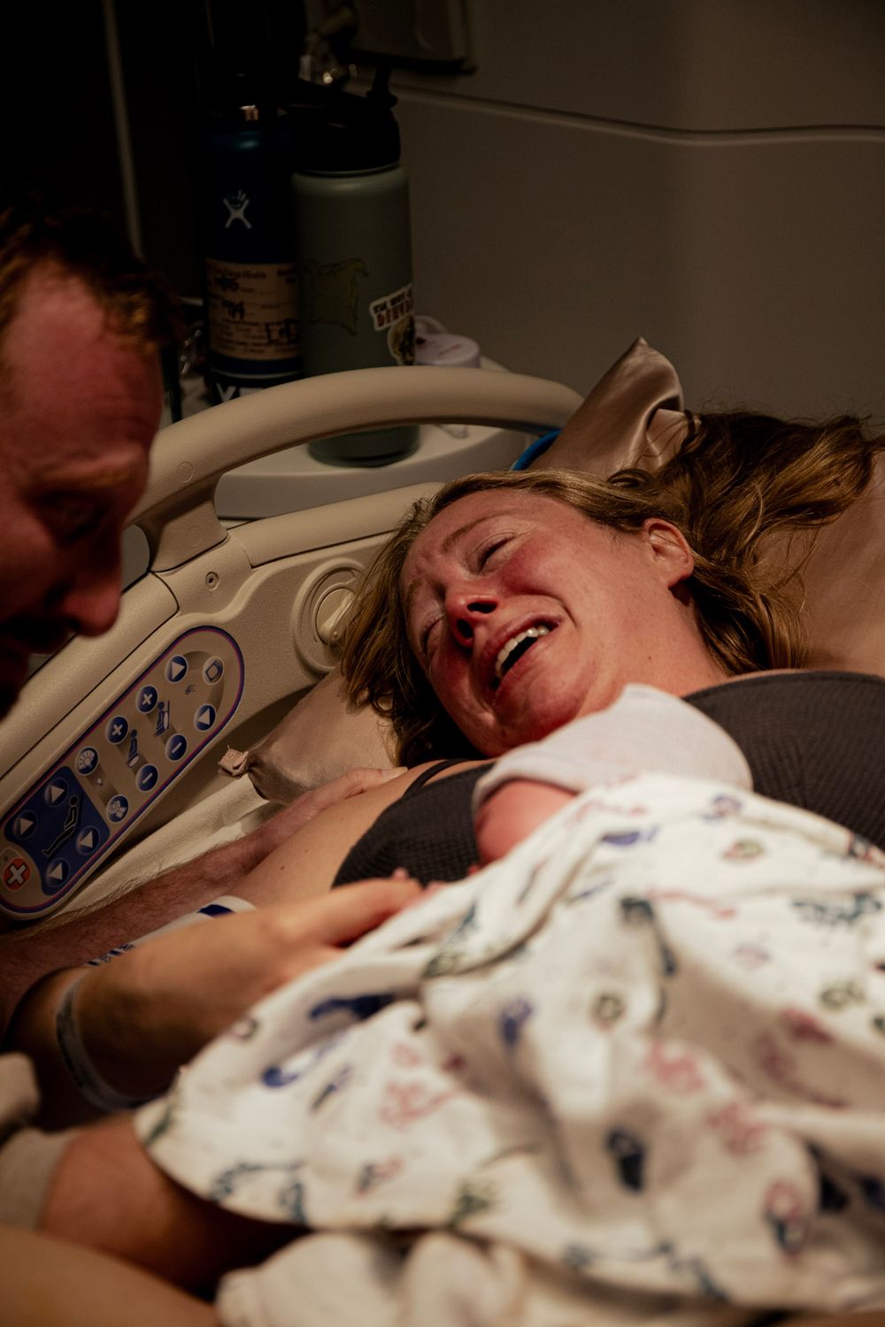 Woman experiencing intense moments during childbirth in hospital delivery room.