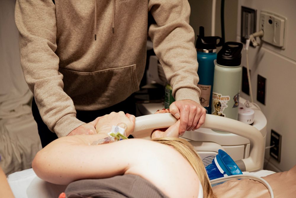 Medical professional providing care to patient on hospital bed.