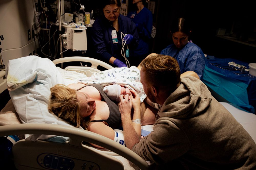 Medical staff attending to patient during labor in hospital delivery room.