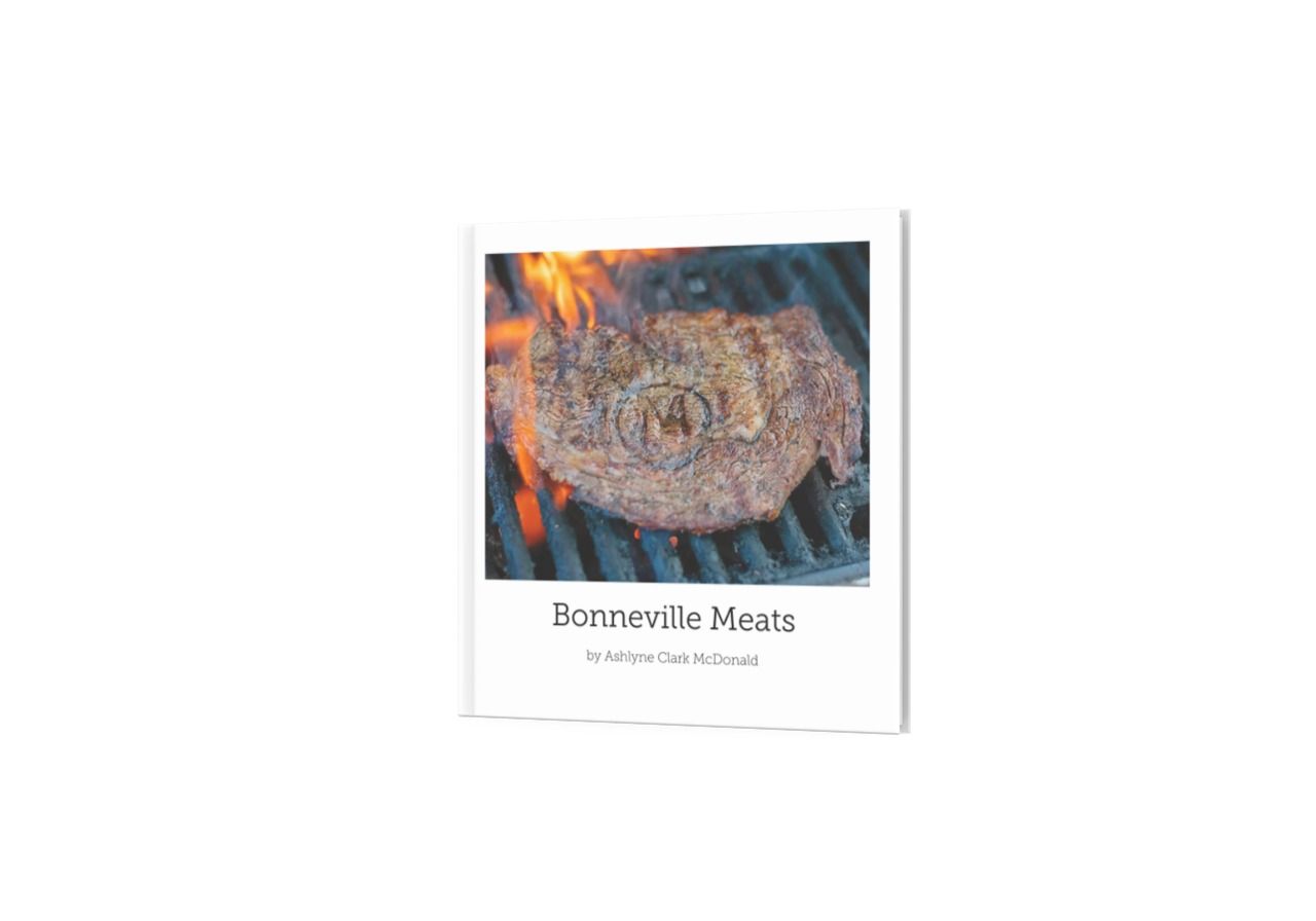 A grilled hamburger patty with flames on a barbecue grill.
