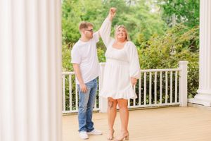 Sun-lit veranda with white columns frames couple's romantic photoshoot.