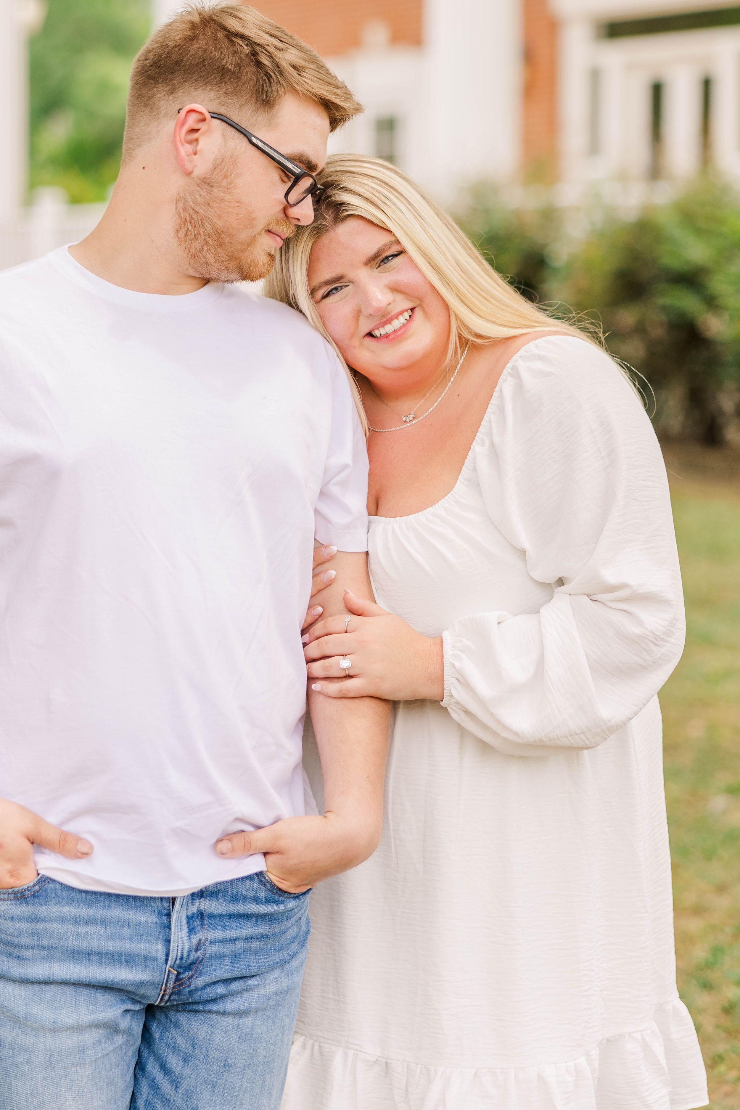 Casual couple in white and denim share playful moments by classical columns.