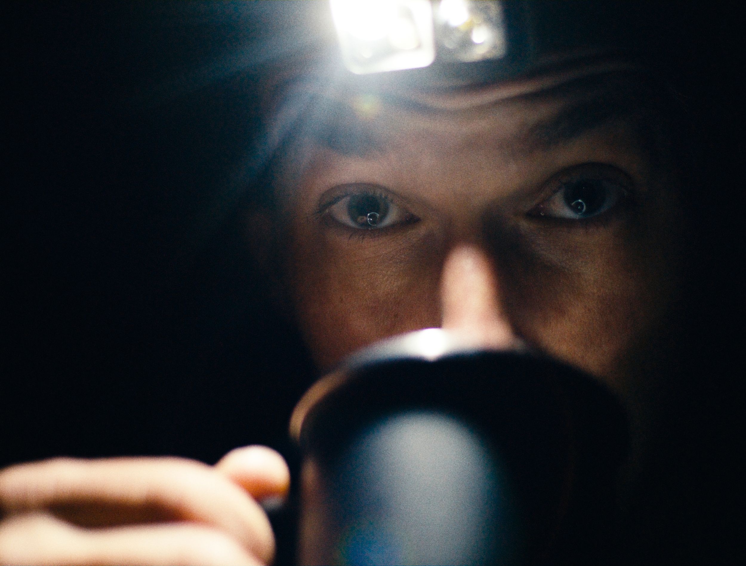 Close-up shot of Joel Ducrot with a headlamp in dark conditions.