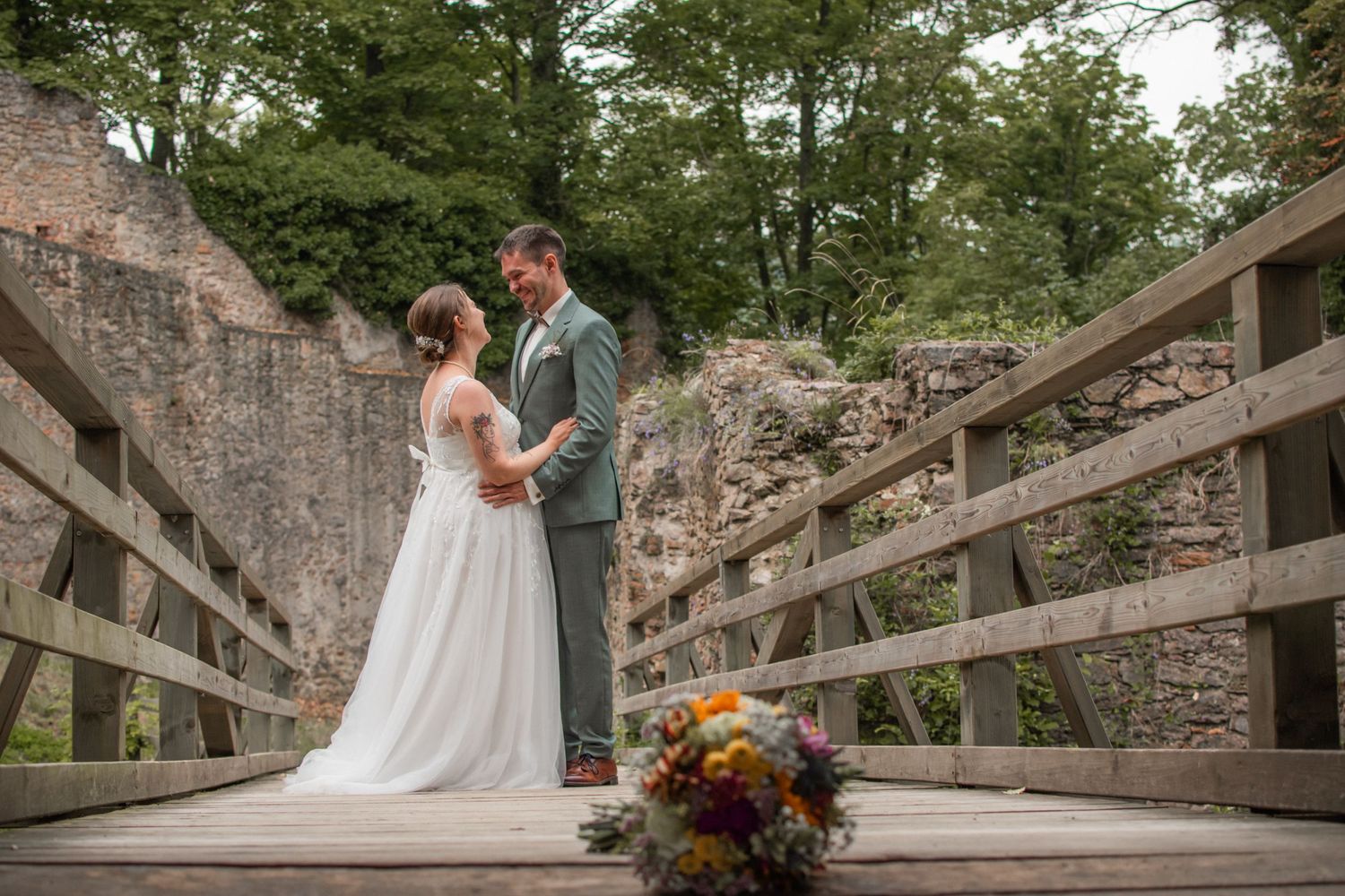 A romantic wedding moment captured with flowing white veil and blue sky in the background.