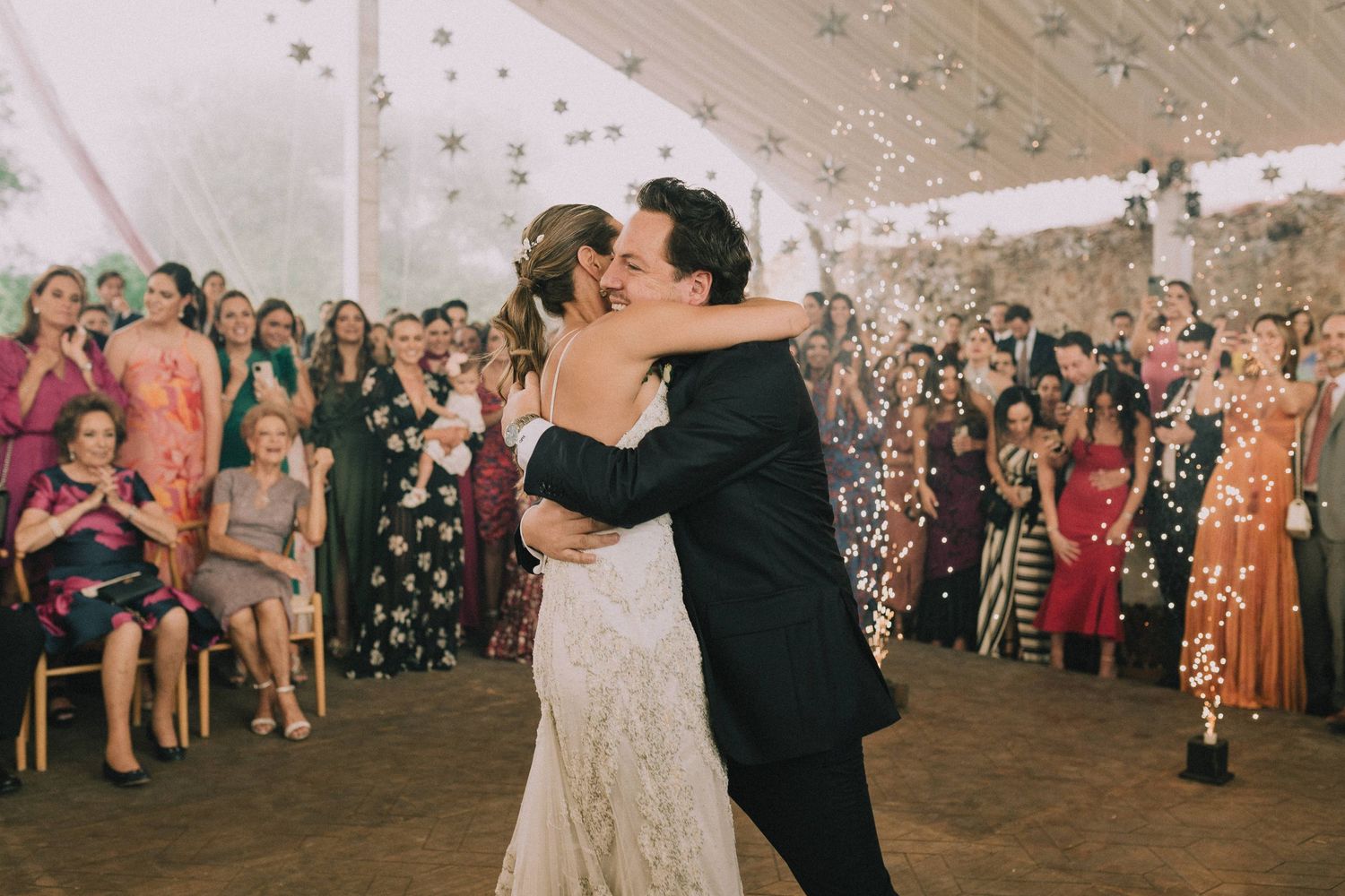 Wedding celebration with guests throwing confetti during a joyous outdoor reception.