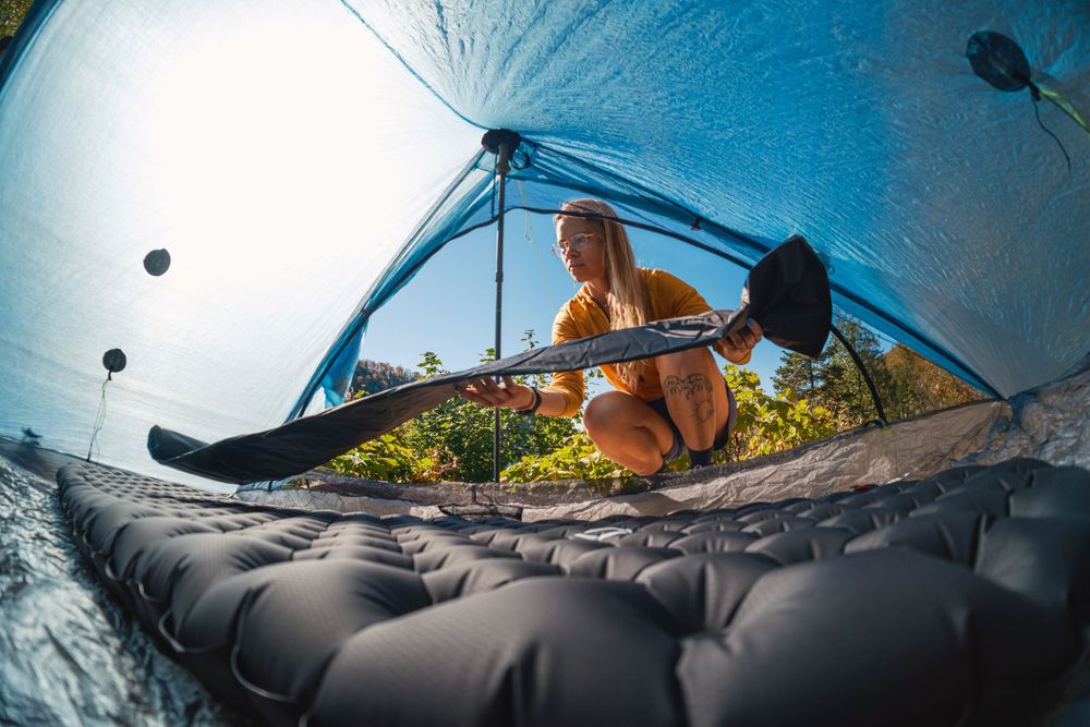 Kayaker paddles through clear blue water while exploring a scenic coastal cave with dramatic rock formations.