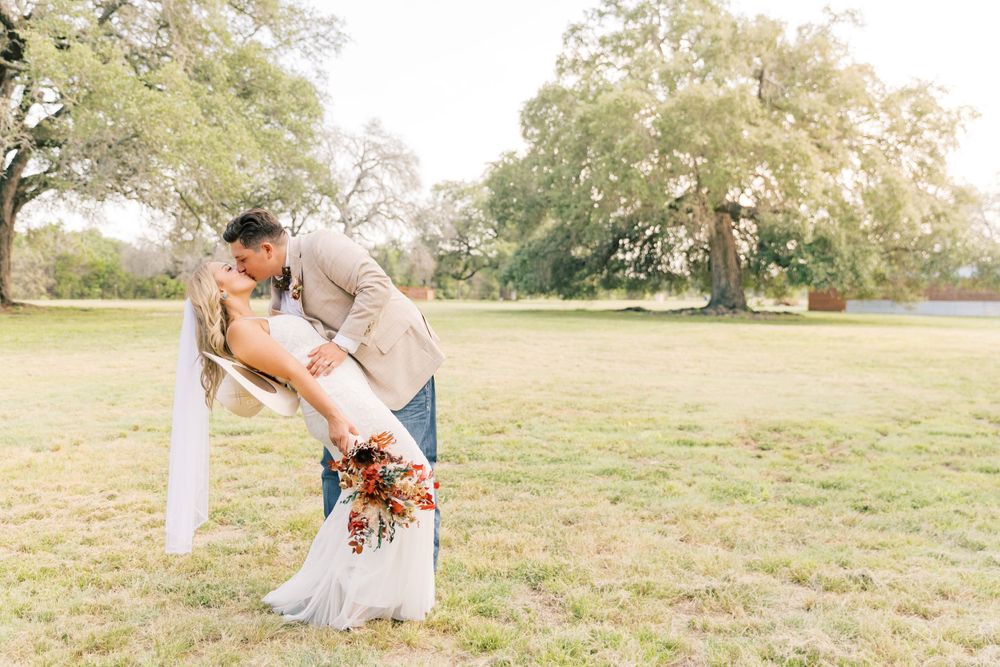 Rustic outdoor wedding photo session in a golden sunset field.