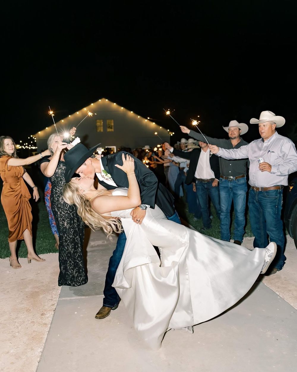 Wedding reception dance line with guests in western attire performing coordinated moves.