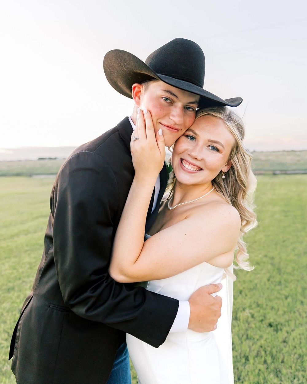 Country western themed engagement photos with couple in black hat and formal wear.