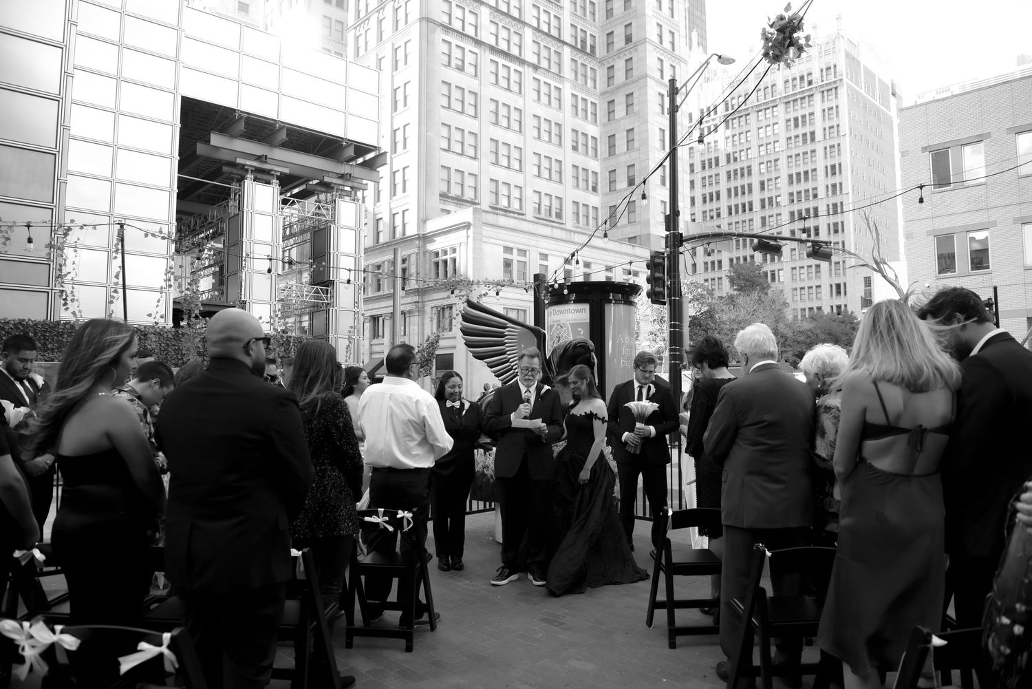 A crowd gathers at Pegasus Brewery and street poles in black and white photography during a same-sex wedding in downtown, Dallas, Texas
