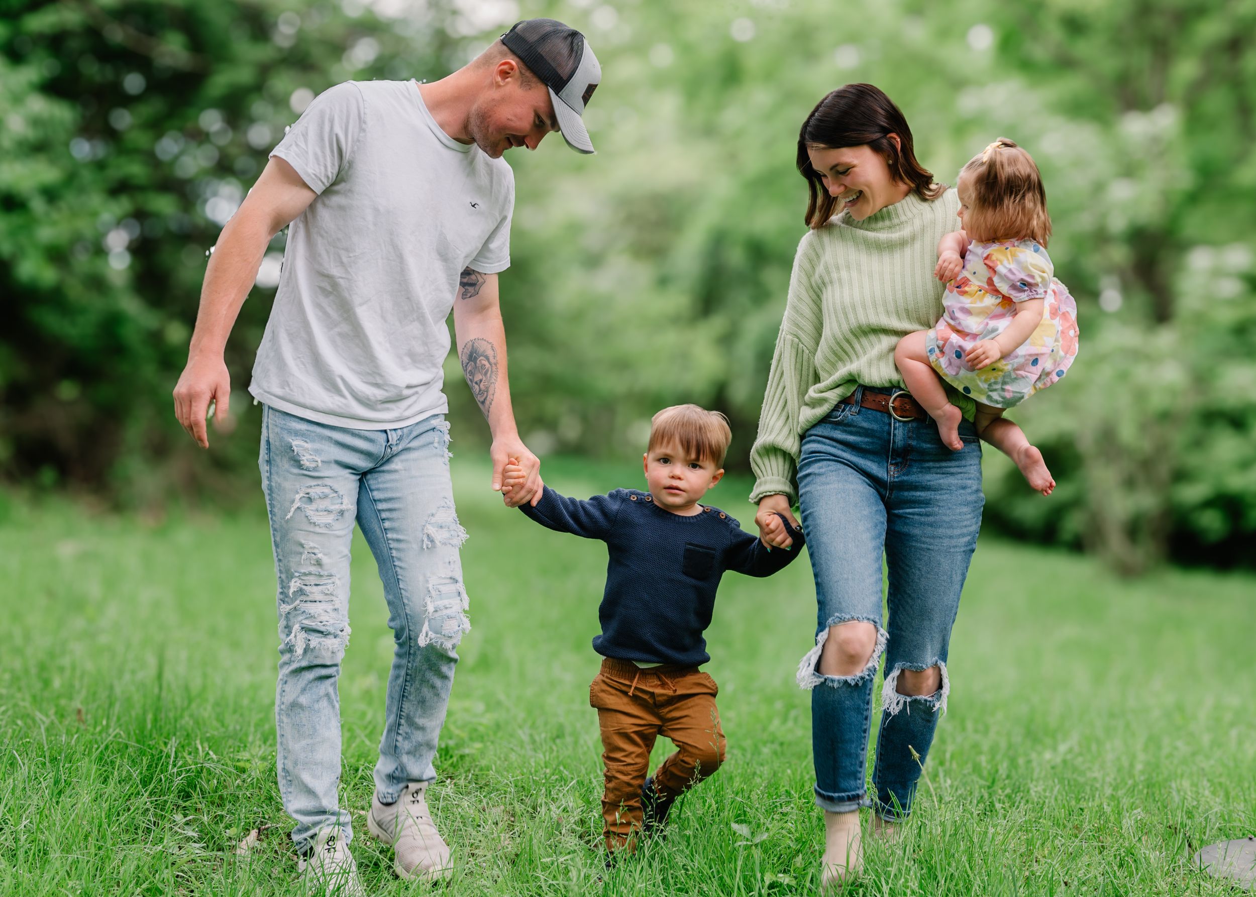 Group spending time together outdoors in a green field while walking and holding hands on a sunny day.