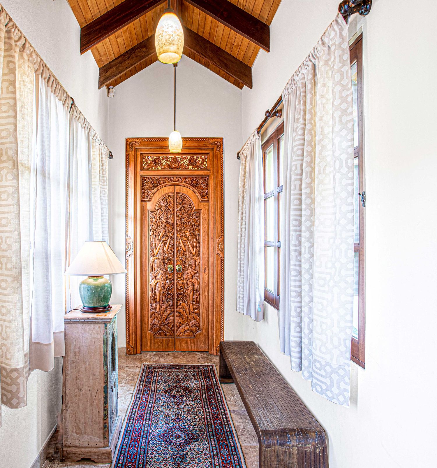 Beautifully crafted wooden door in a luxury property hallway in Costa Rica, showcasing intricate design and natural lighting