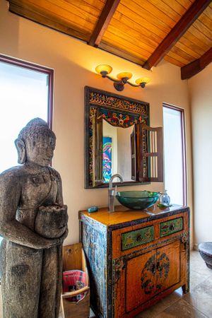 Carved wooden Buddha statue and antique furniture, adding a cultural element to the property